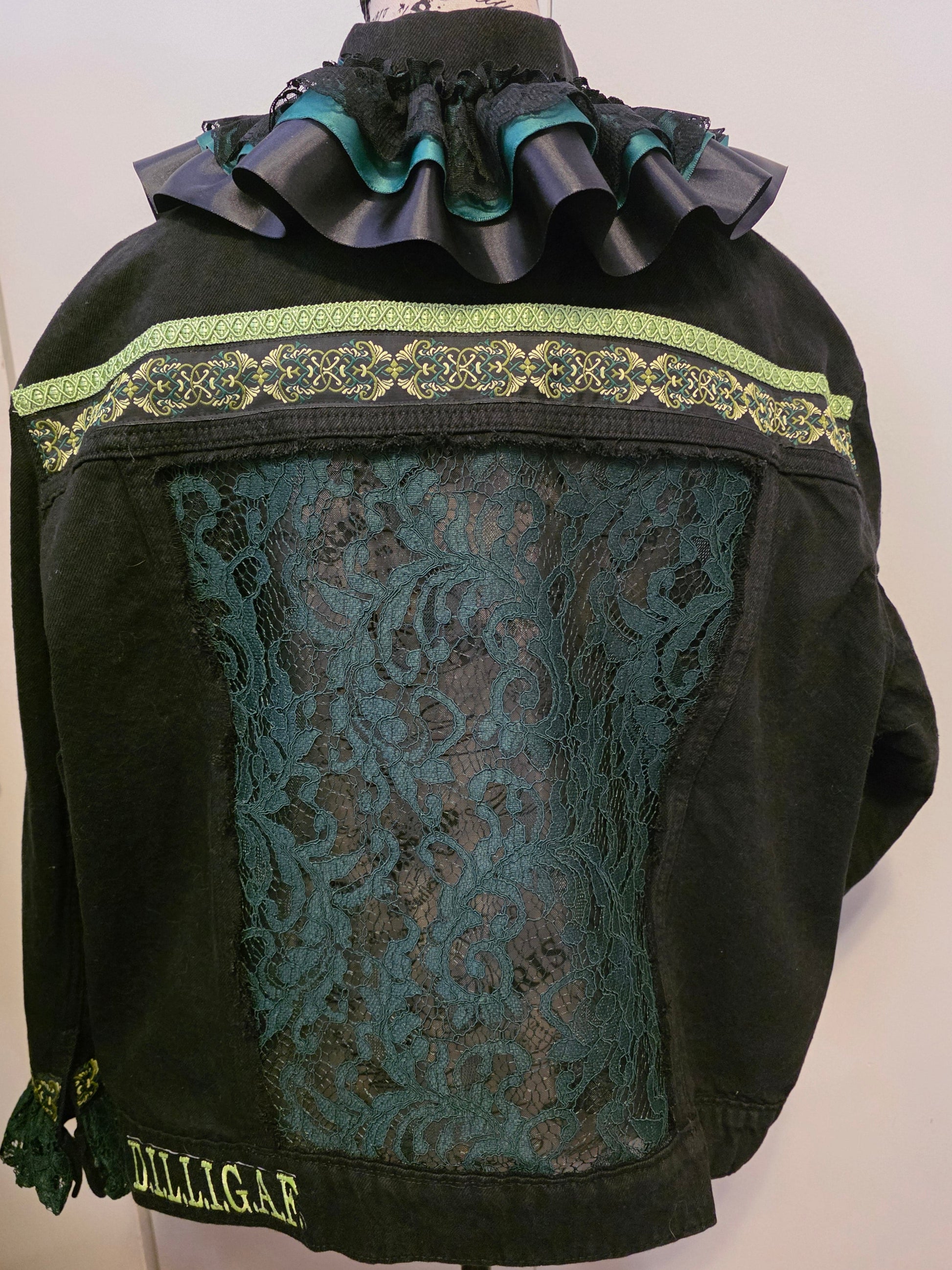 Black bag with decorative green trim and floral pattern on a white background