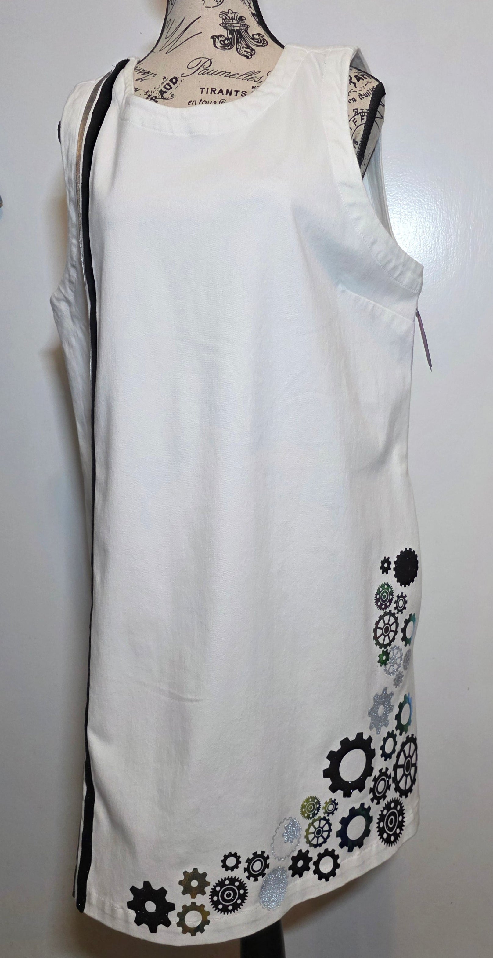 white denim shift dress hand embellished with black, silver and holographic green/gold foil steampunk gears arranged asymmetrically along the hem