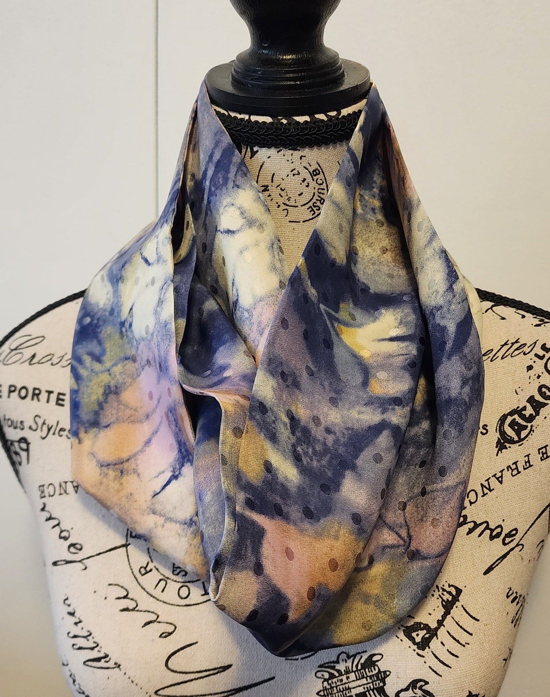 Ungaro silk scarf is soft blues, touch of rose and amber with  ecru blend in a pattern like water colours mixing on a canvas